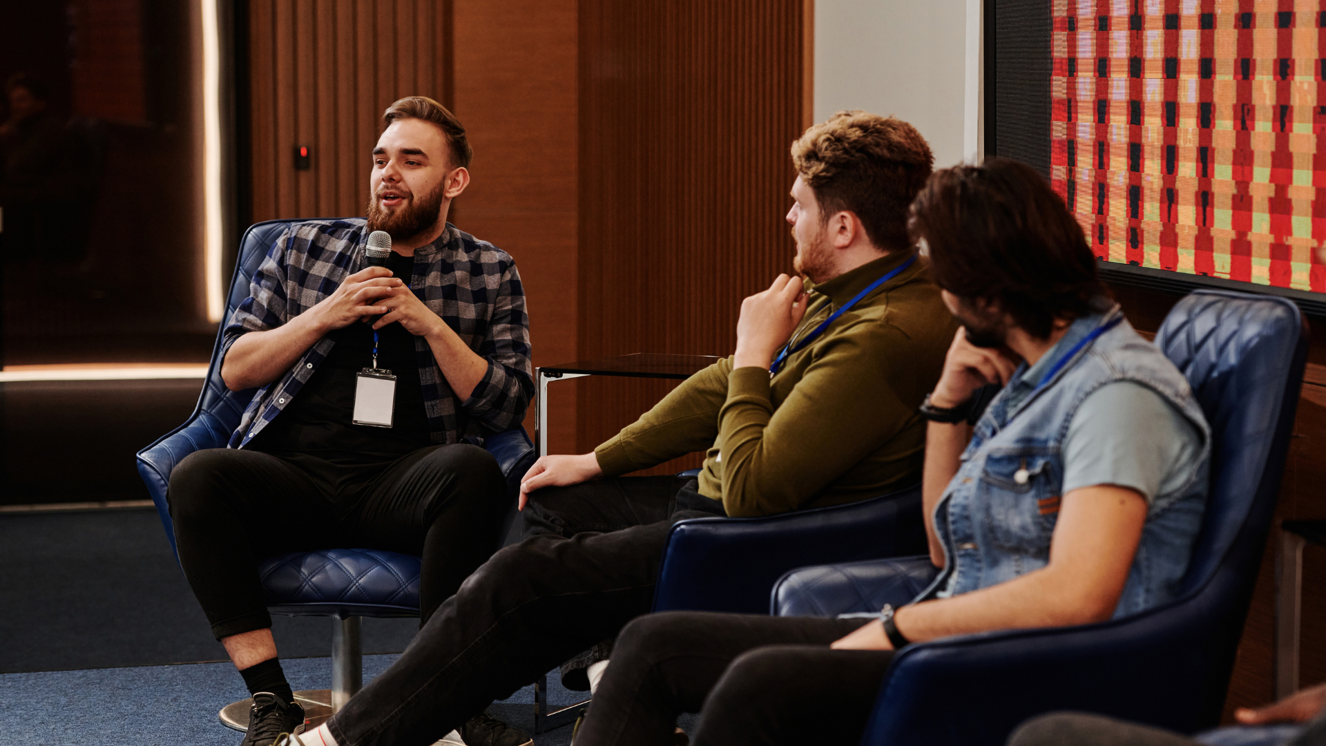 Three men speaking on an educational panel